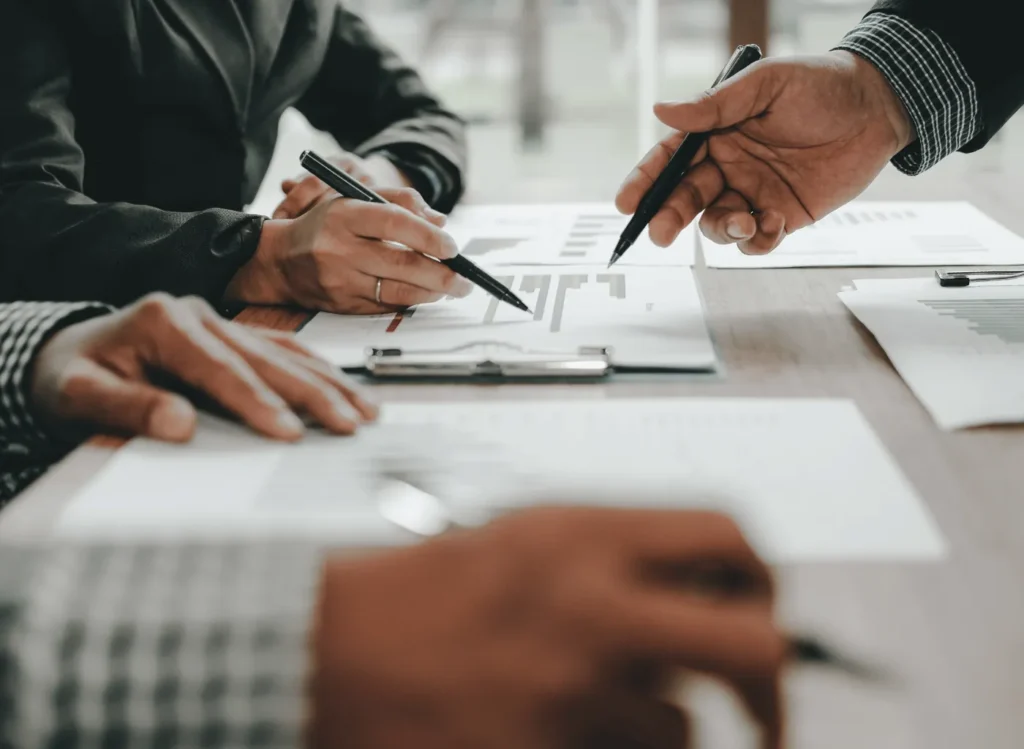 Riunione di lavoro con penne su documenti e grafici